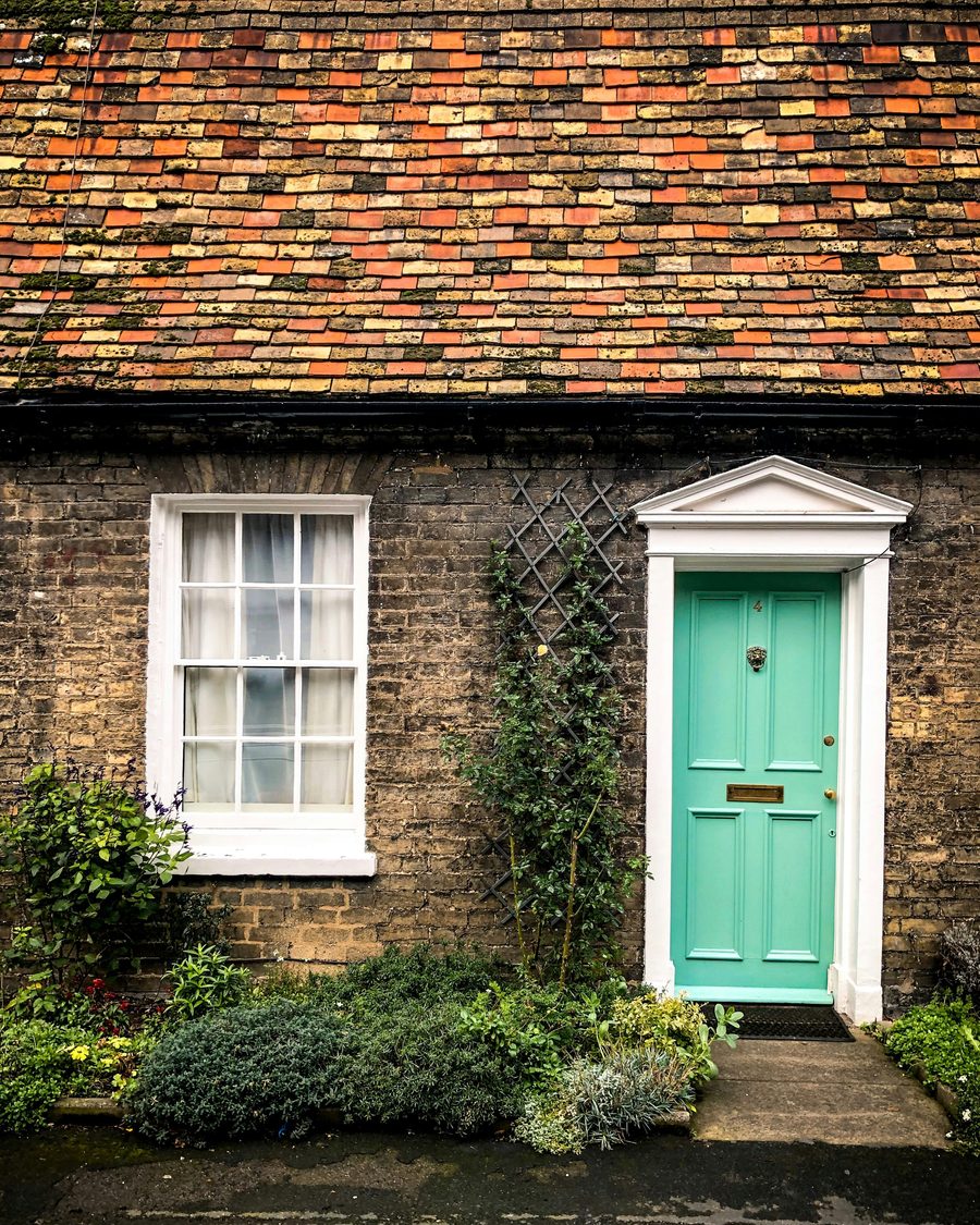 A brick cottage with a mint green front door